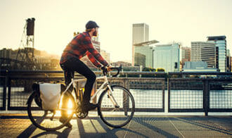 man riding bike over Willamette River